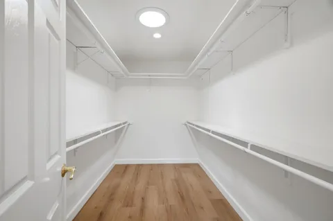 a view of walk in closet with wooden floor