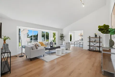 a living room with furniture and a table with wooden floor