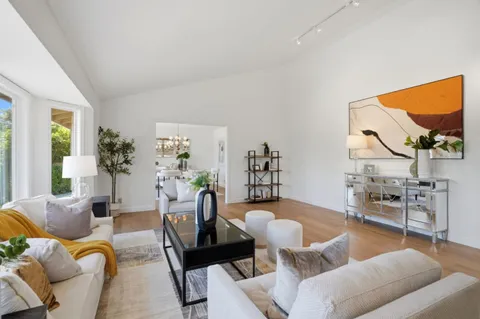 a living room with furniture kitchen view and a large window