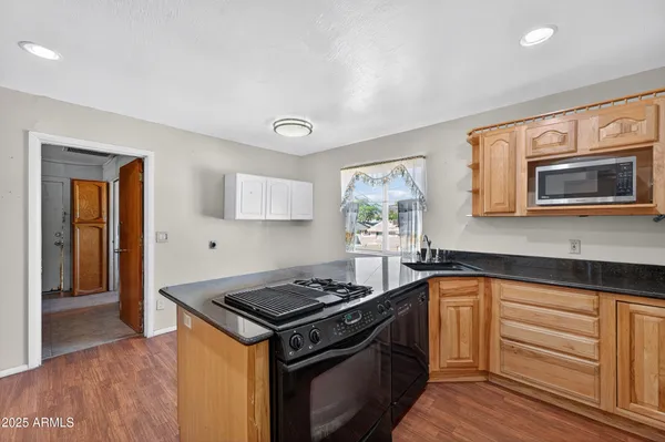 a kitchen with stainless steel appliances granite countertop a stove and a microwave