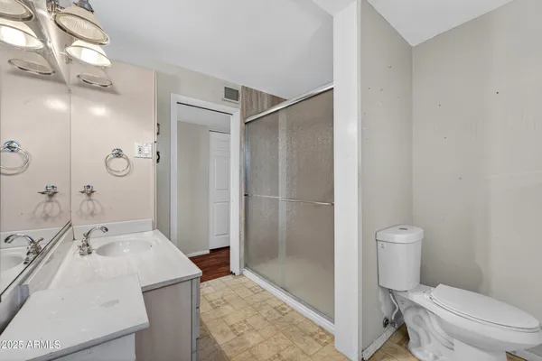 a spacious bathroom with a double vanity sink a mirror and a