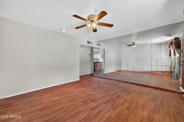 a view of a livingroom with a ceiling fan wooden floor and a ceiling fan