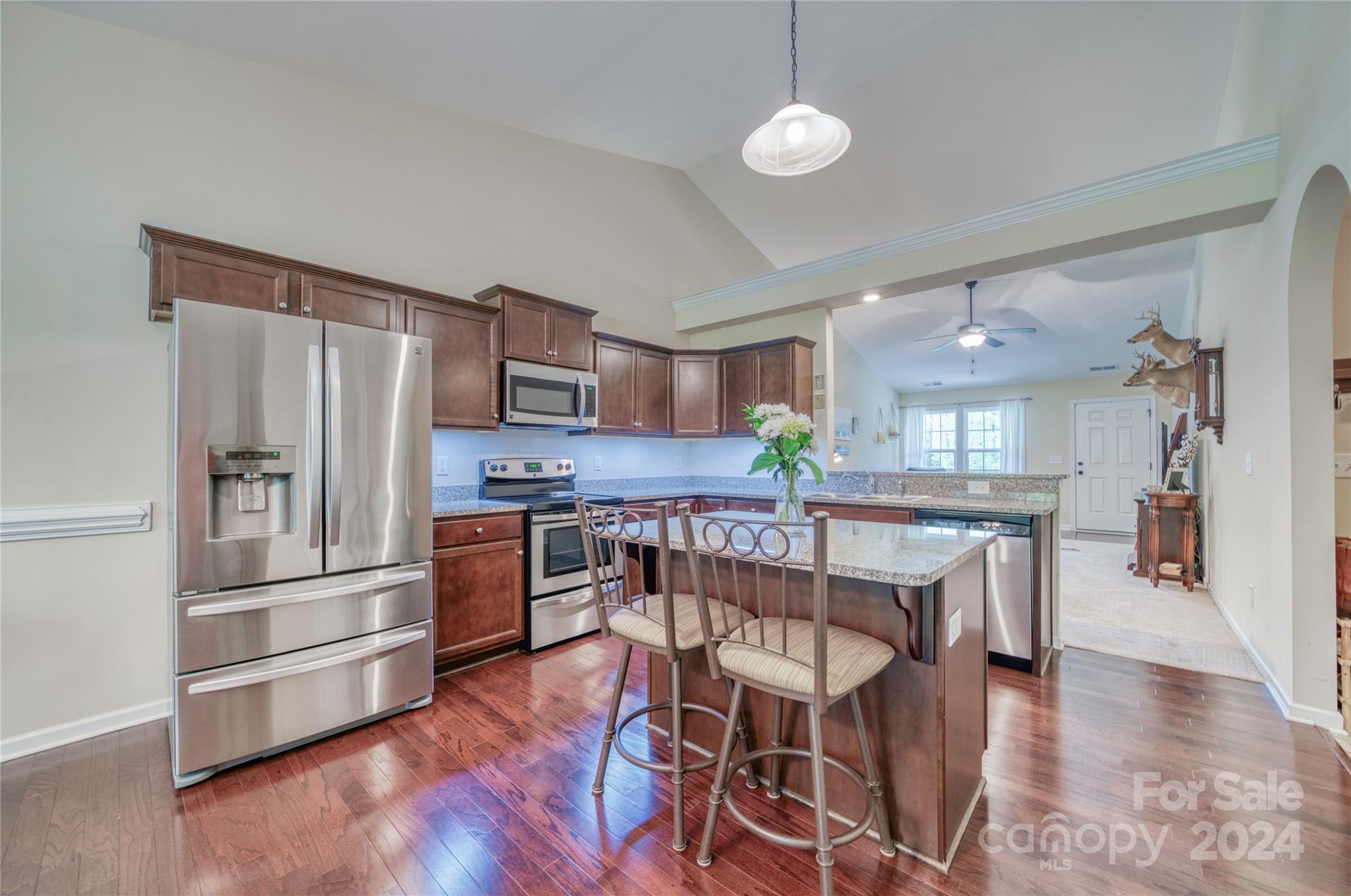 303 Reservation Road Catawba, SC 29704 - Photo 14 of 32 a kitchen with stainless steel appliances a refrigerator a stove a sink a dining table and chairs with wooden floor