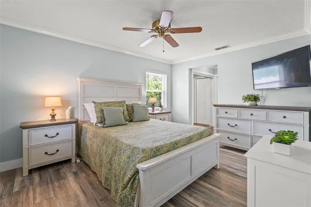 a bedroom with a bed and a flat tv screen on dresser