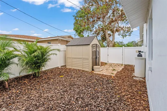 a view of a patio with a dining table and chairs next to a yard