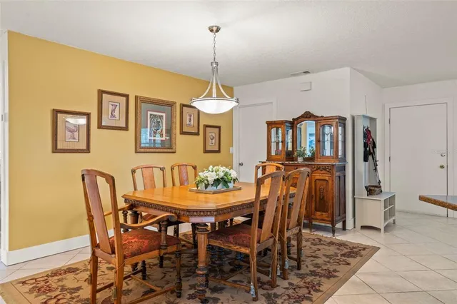 a dining room with granite countertop a table chairs and a chandelier