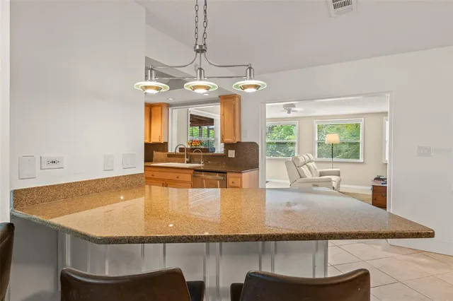 a kitchen with granite countertop a sink stainless steel appliances and cabinets