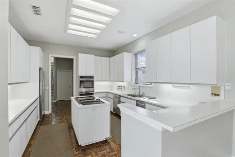 a kitchen with kitchen island a sink stove and refrigerator