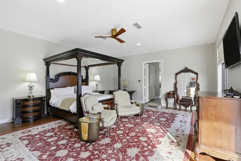 a bedroom with a bed a flat screen tv and a window