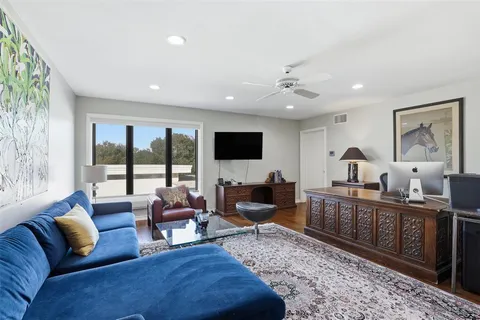 a living room with furniture flat screen tv and a large window