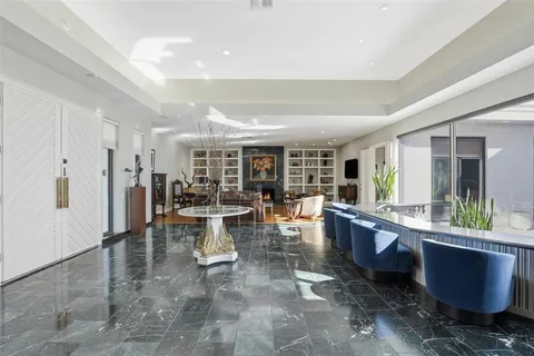 a dining hall with stainless steel appliances granite countertop a table chairs and a refrigerator