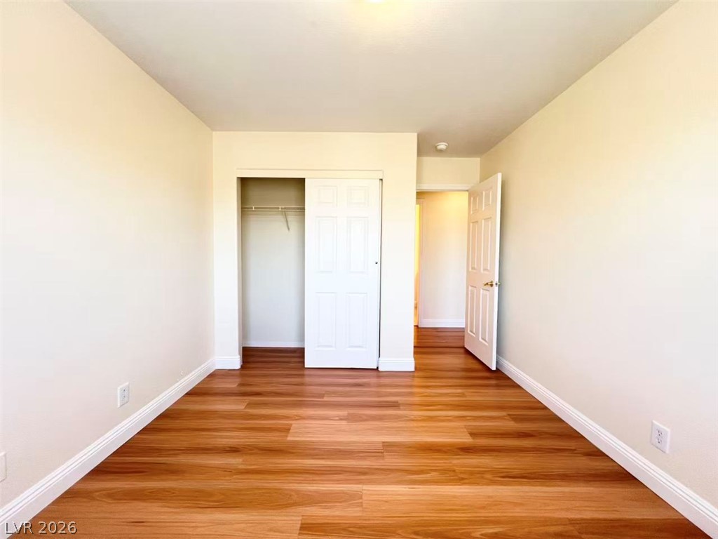 9891 Ridge Hill Avenue Las Vegas, NV 89147 - Photo 23 of 29 A well-lit bedroom features lustrous hardwood flooring and an ample closet for storage.