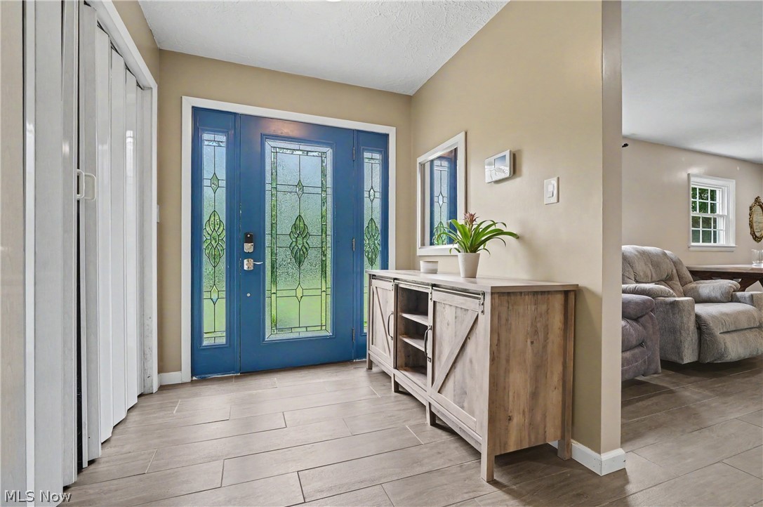 952 Ravenna Road Kent, OH 44240 - Photo 3 of 37 Entryway featuring a blue door with decorative glass inserts and sidelights.