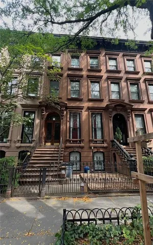 front view of a brick house with a small yard