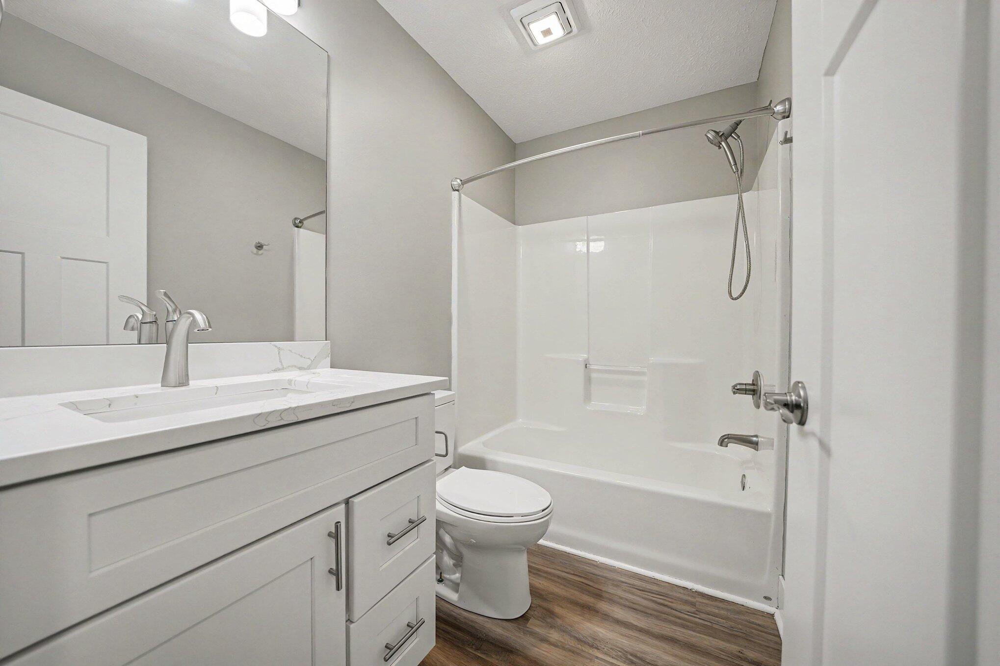 7563 East 400 North Rolling Prairie, IN 46371 - Photo 11 of 17 a bathroom with a granite countertop sink toilet a shower and a mirror