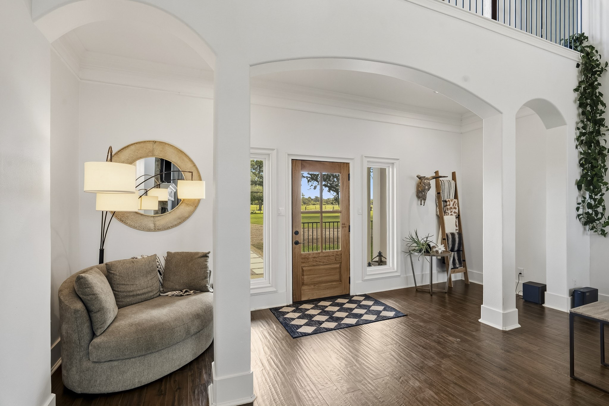 3103 Brundrett Road Wallis, TX 77485 - Photo 8 of 45 This look back showcases the home's spacious and welcoming Foyer, thoughtfully designed with ample room for a stylish coat rack, bench seating, and a storage console. The beautiful glass-plated front door, framed by expansive picture-window sidelights, invites an abundance of natural light inside, creating a bright and airy introduction that seamlessly flows into the main living space.