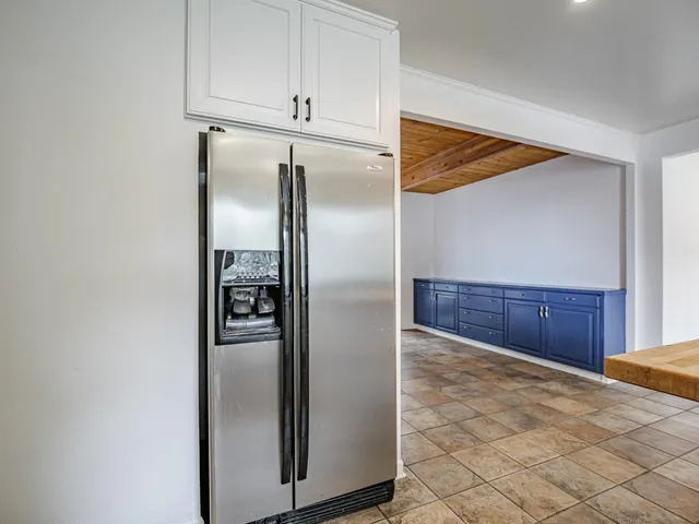 a view of an empty room with window and chandelier
