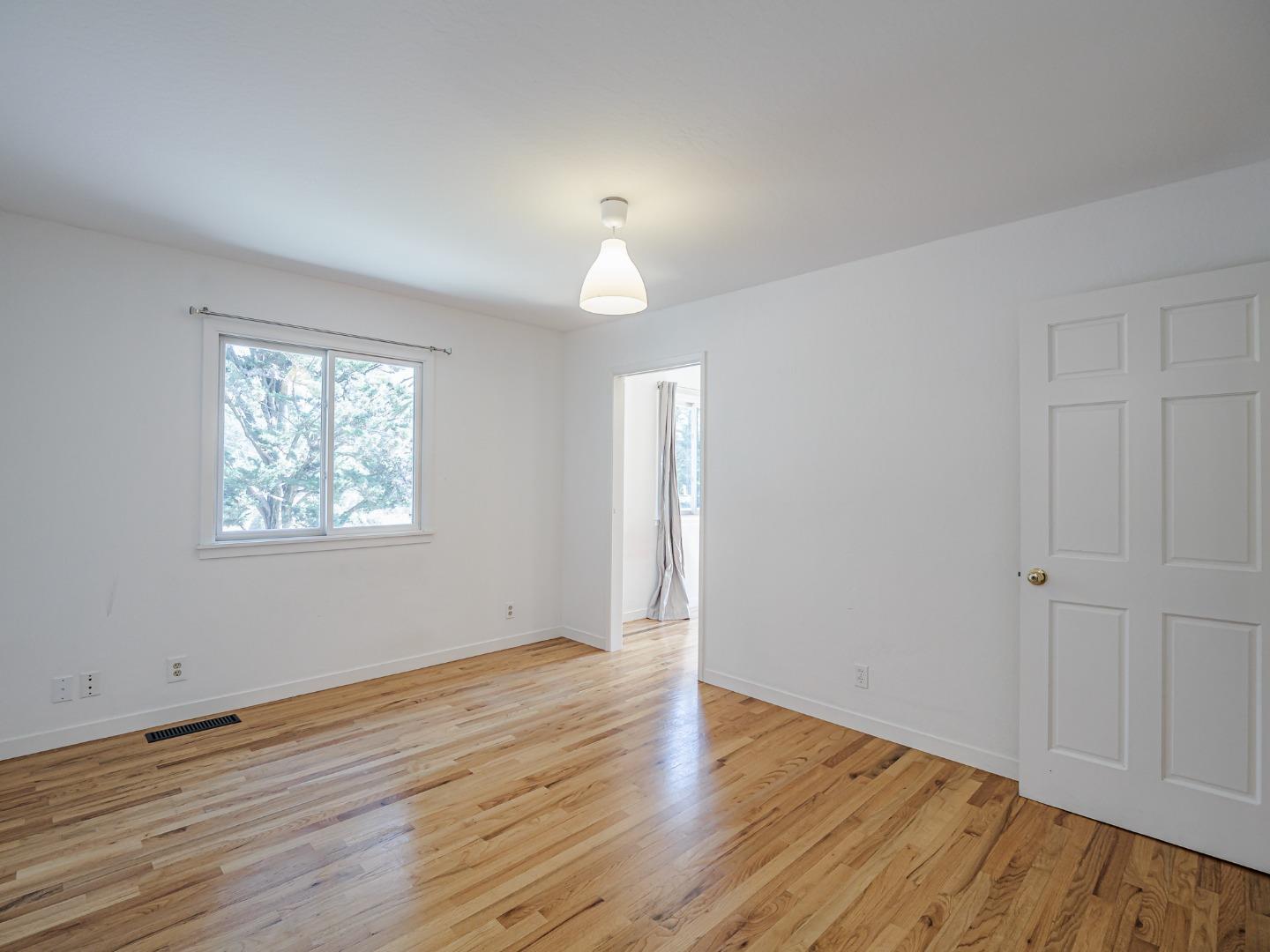 1459 High Street Santa Cruz, CA 95060 - Photo 31 of 62 an empty room with wooden floor chandelier and windows