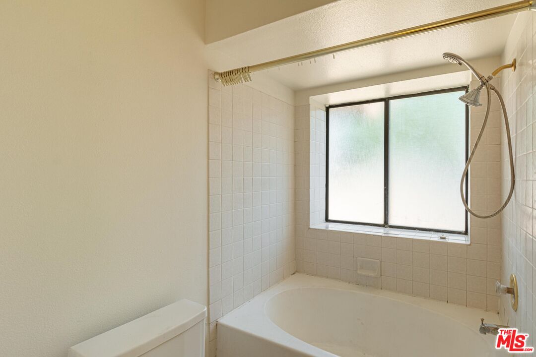 1217 Ave H4 Lancaster, CA 93534 - Photo 14 of 18 a bathroom with a bathtub and a shower