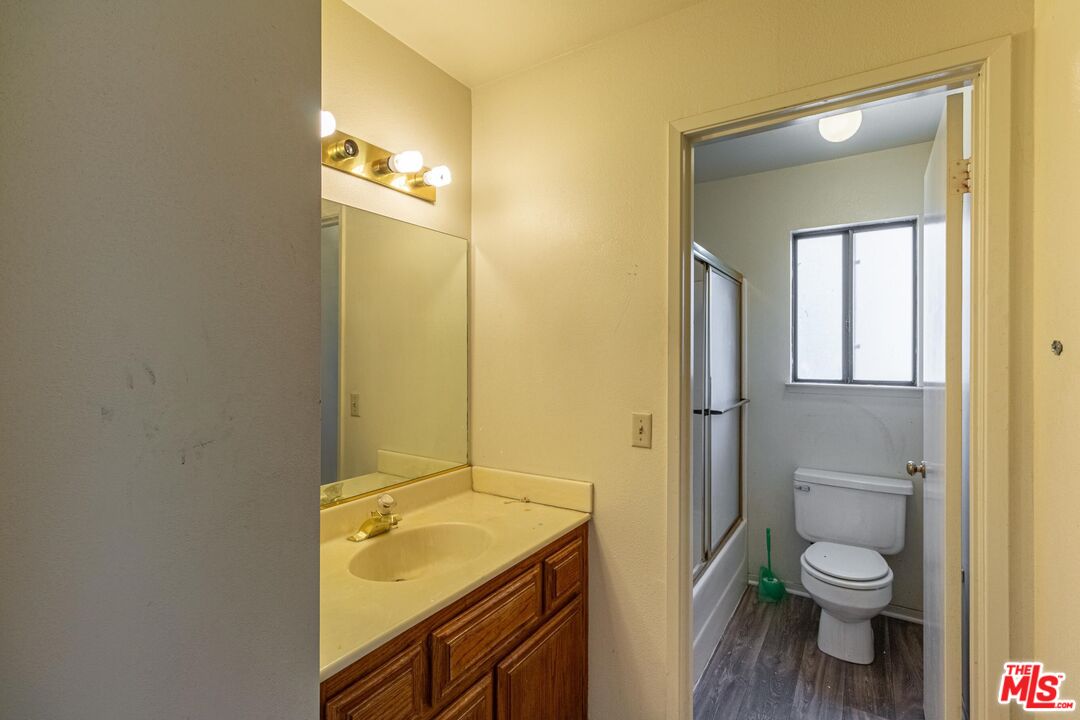 1217 Ave H4 Lancaster, CA 93534 - Photo 16 of 18 a bathroom with a granite countertop toilet a sink and a mirror
