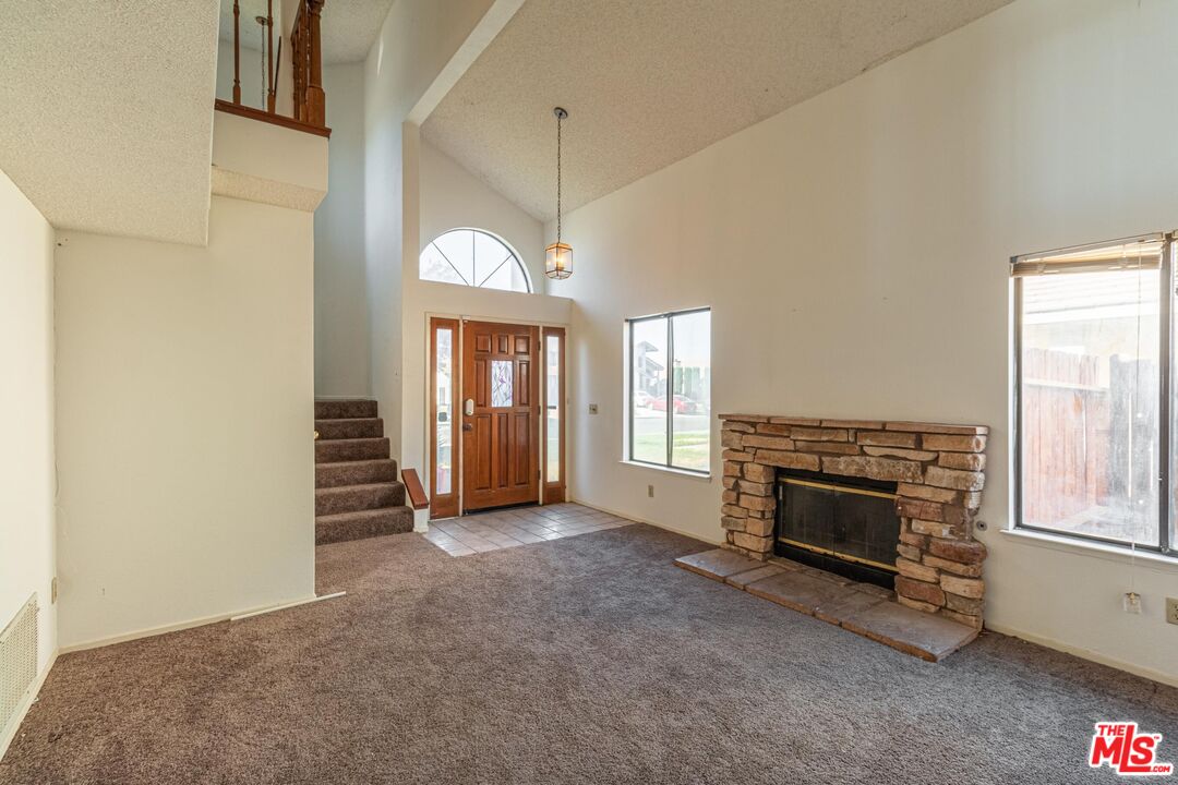 1217 Ave H4 Lancaster, CA 93534 - Photo 2 of 18 an empty room with windows fireplace and microwave