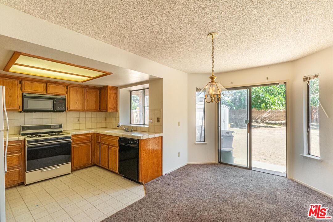 1217 Ave H4 Lancaster, CA 93534 - Photo 4 of 18 a kitchen with stainless steel appliances granite countertop a stove and a sink