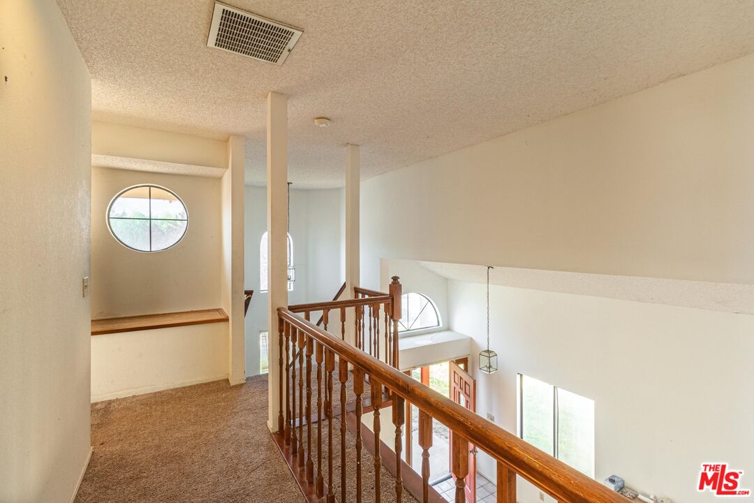 1217 Ave H4 Lancaster, CA 93534 - Photo 8 of 18 a view of a hallway with wooden floor and windows