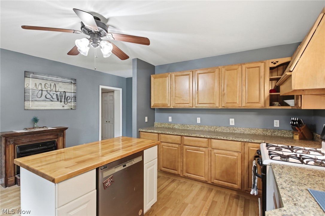 2591 Wayland Road Deerfield, OH 44411 - Photo 11 of 46 Kitchen featuring wood-finish flooring, a central island with a butcher block countertop and built-in dishwasher, light wood cabinetry, and speckled countertops