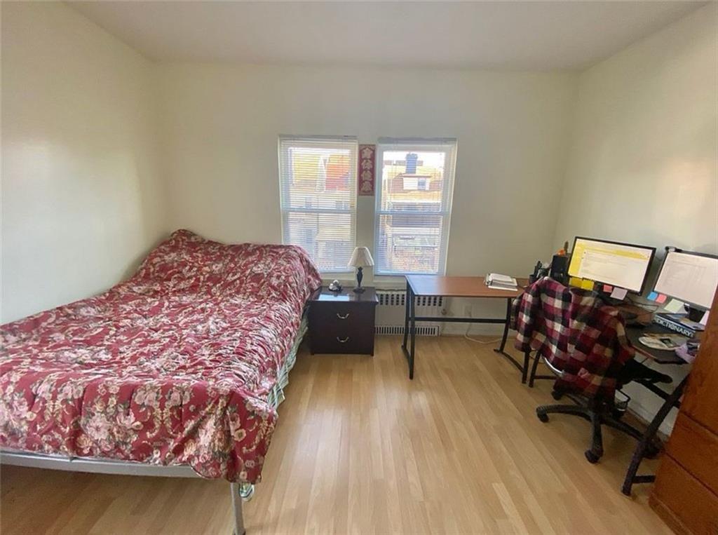 1727 East 16th Street Brooklyn, NY 11229 - Photo 27 of 35 a bedroom with a bed a table and chair