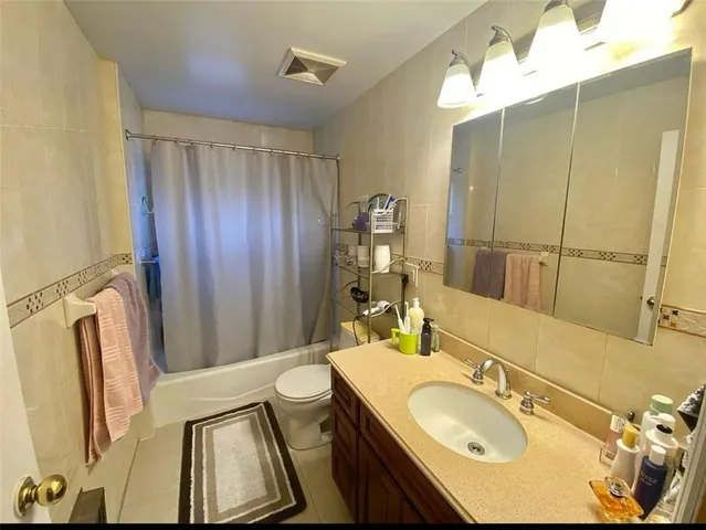 a bathroom with a sink vanity granite tub and shower