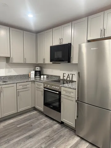 a kitchen with a refrigerator stove and white cabinets