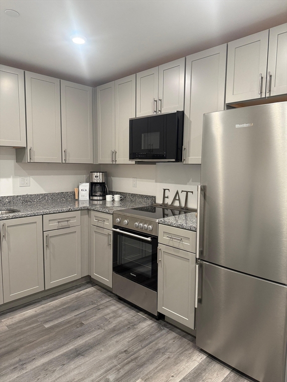 a kitchen with a refrigerator stove and white cabinets