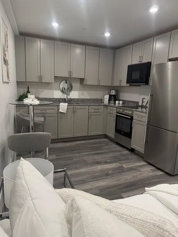 a kitchen with stainless steel appliances kitchen island granite countertop a refrigerator sink and microwave