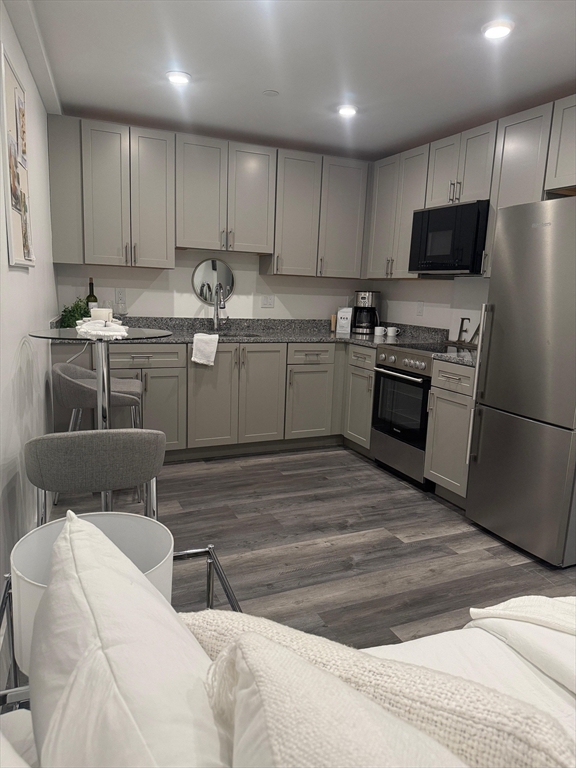 585 Essex Street, Unit 519 Lynn, MA 01901 - Photo 2 of 19 a kitchen with stainless steel appliances kitchen island granite countertop a refrigerator sink and microwave