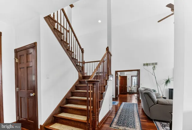 a living room with furniture stairs and a chandelier