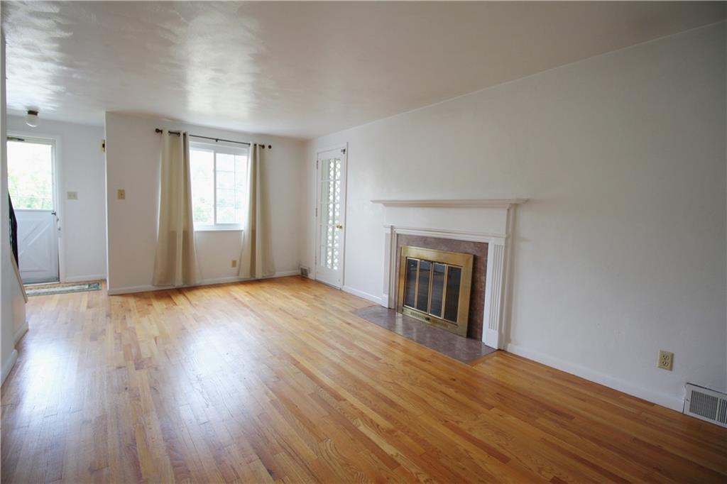 515 Filmore Road Pittsburgh, PA 15221 - Photo 4 of 14 an empty room with wooden floor and windows