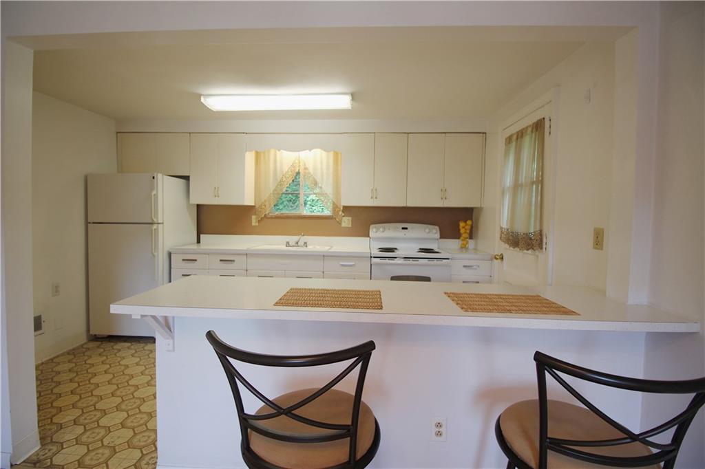 515 Filmore Road Pittsburgh, PA 15221 - Photo 7 of 14 a kitchen with a table chairs and a refrigerator