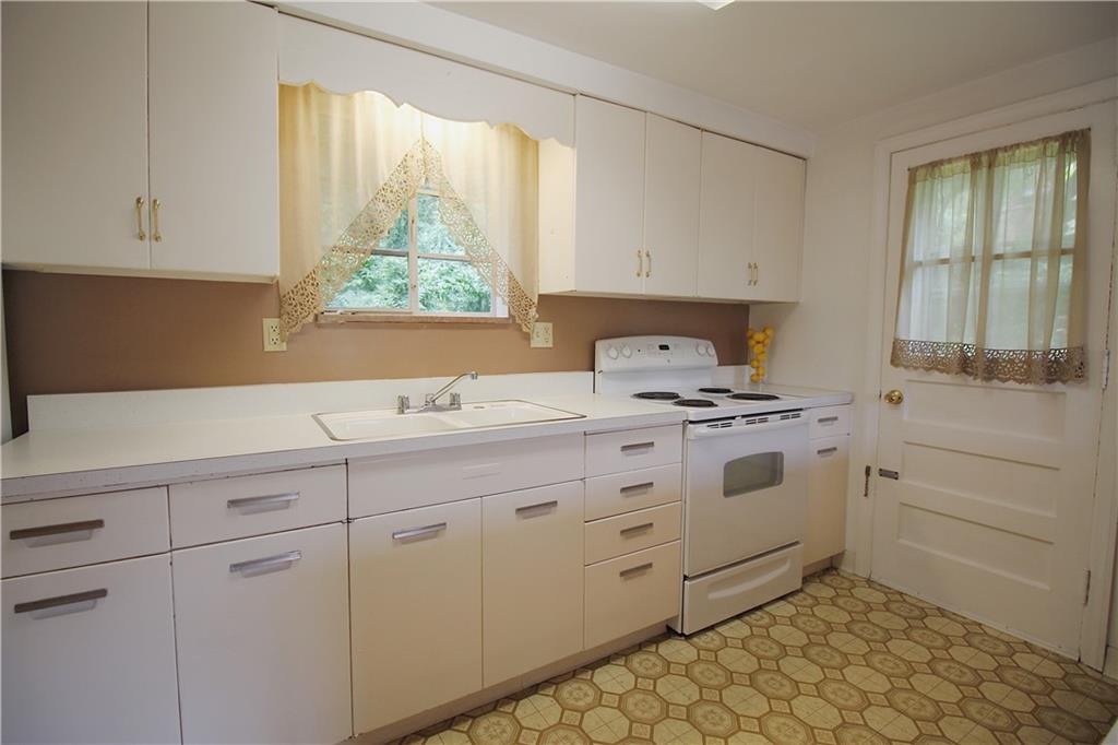 515 Filmore Road Pittsburgh, PA 15221 - Photo 8 of 14 a kitchen with white cabinets and window