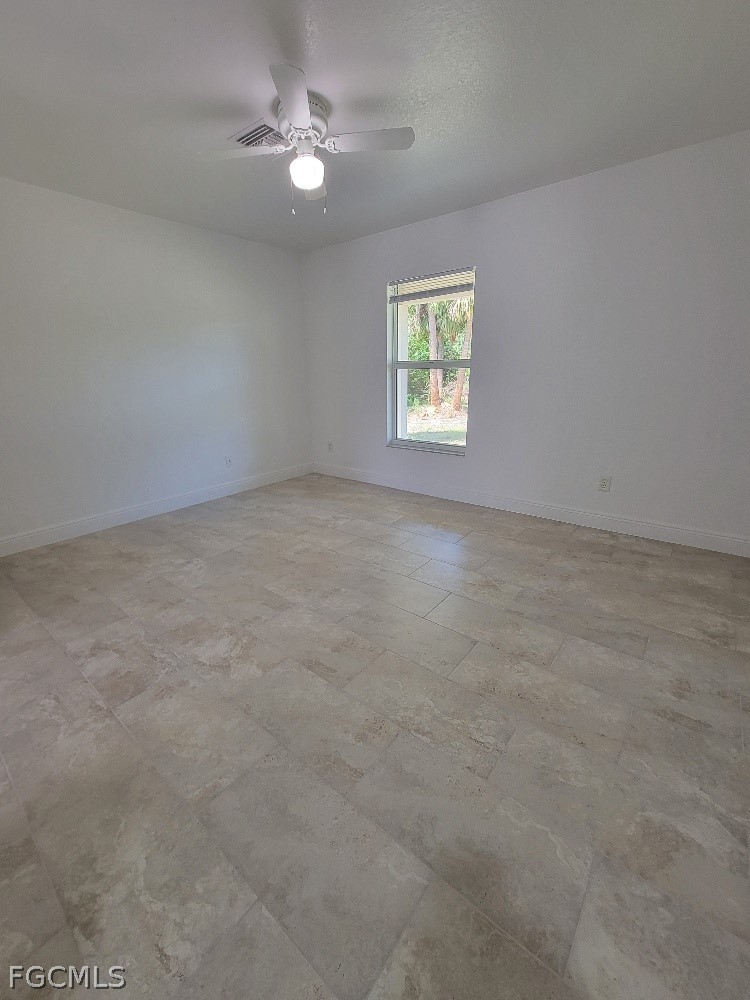 355 Paddock Street Lehigh Acres, FL 33974 - Photo 14 of 29 an empty room with windows and fan