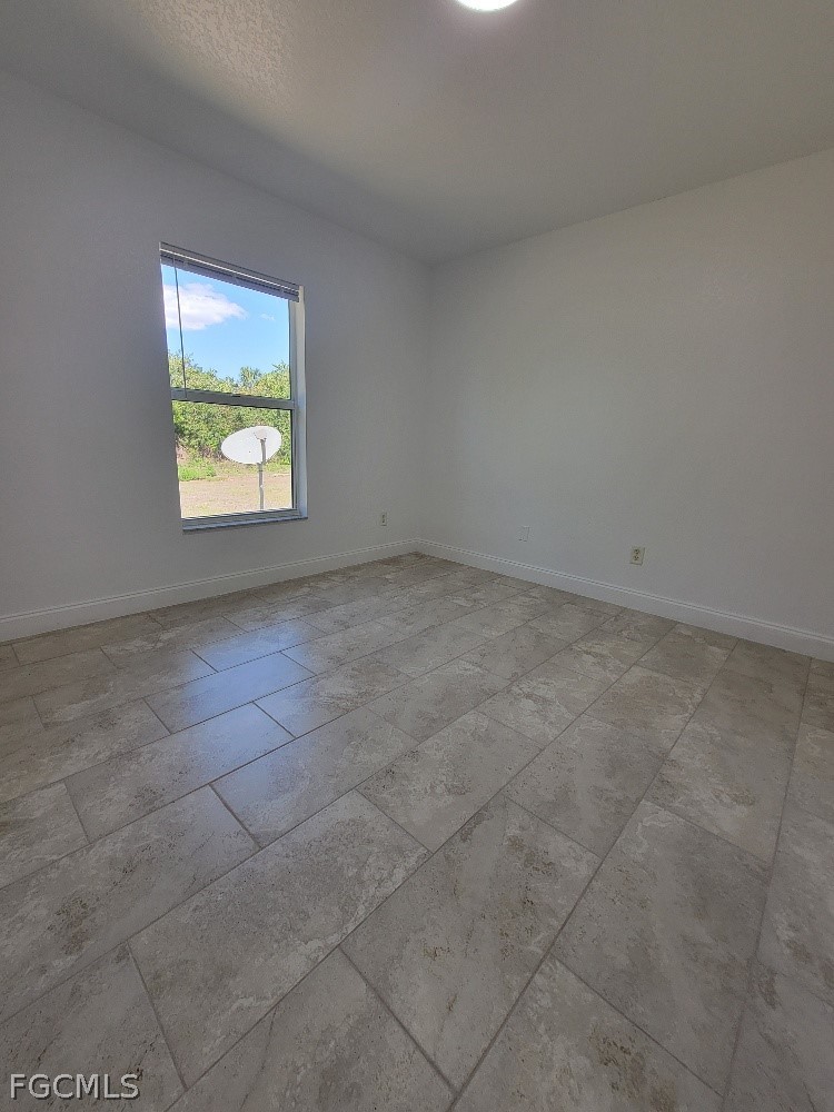 355 Paddock Street Lehigh Acres, FL 33974 - Photo 22 of 29 an empty room with windows