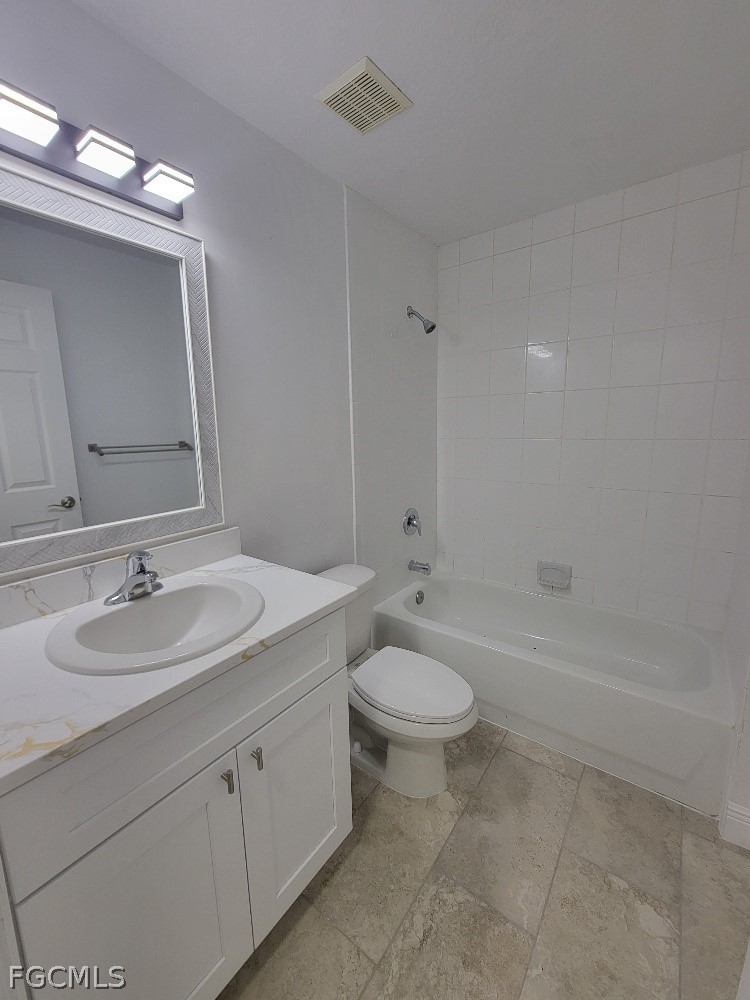 355 Paddock Street Lehigh Acres, FL 33974 - Photo 24 of 29 a bathroom with a double vanity sink toilet mirror and bathtub