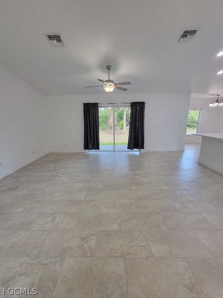 355 Paddock Street Lehigh Acres, FL 33974 - Photo 6 of 29 an empty room with windows and a ceiling fan