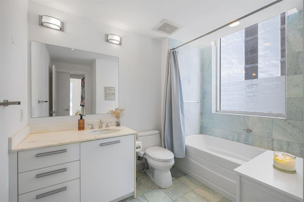 1050 Brickell Avenue, Unit 2302 Miami, FL 33131 - Photo 11 of 50 a bathroom with a double vanity sink toilet mirror and bathtub