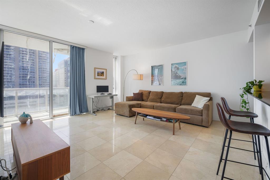 1050 Brickell Avenue, Unit 2302 Miami, FL 33131 - Photo 28 of 50 a living room with furniture and a floor to ceiling window