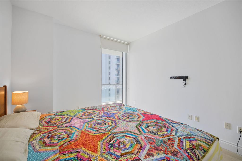 1050 Brickell Avenue, Unit 2302 Miami, FL 33131 - Photo 34 of 50 a bedroom with a bed and a window