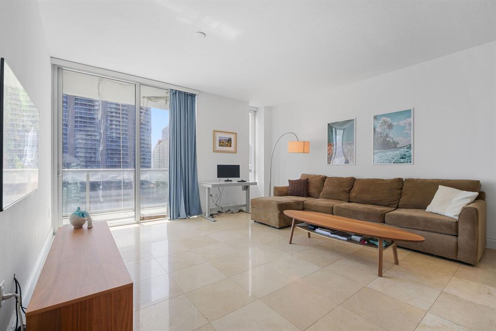 1050 Brickell Avenue, Unit 2302 Miami, FL 33131 - Photo 8 of 50 a living room with furniture and a large window