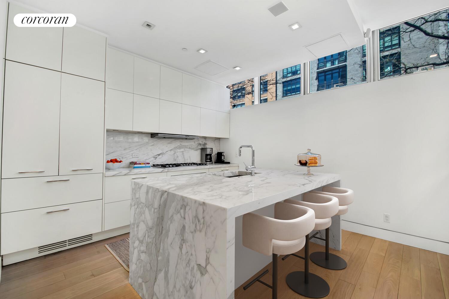 471 Washington Street, Unit THC Manhattan, NY 10013 - Photo 6 of 15 a kitchen with a dining table chairs and white cabinets