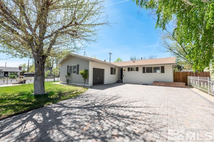 a front view of a house with a garden and trees