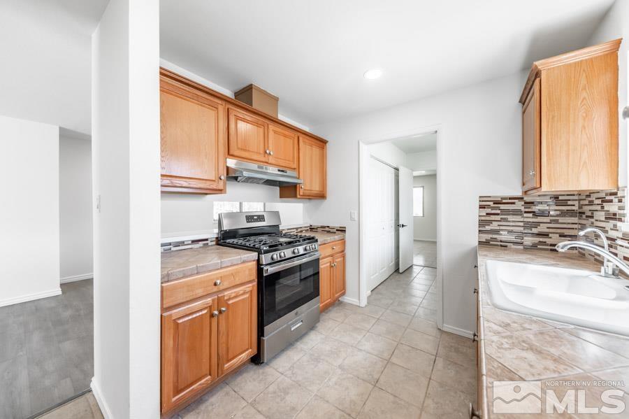 2441 Baxter Way Sparks, NV 89431 - Photo 8 of 25 a kitchen with stainless steel appliances granite countertop a stove a sink and a refrigerator