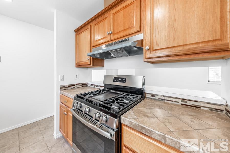 2441 Baxter Way Sparks, NV 89431 - Photo 10 of 25 a kitchen with stainless steel appliances granite countertop a stove and a microwave